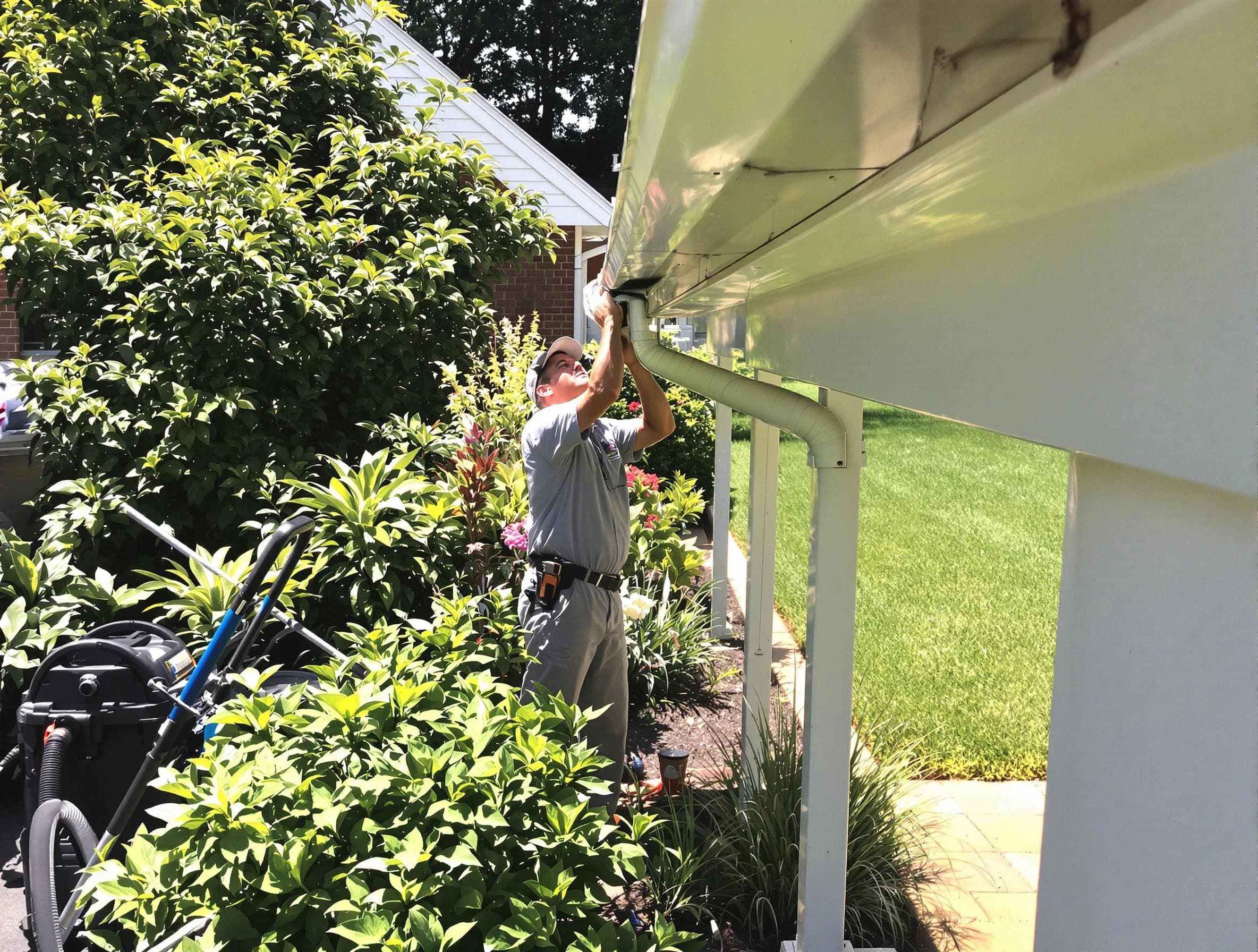 Technician flushing a blockage from a downspout in Tallmadge, OH